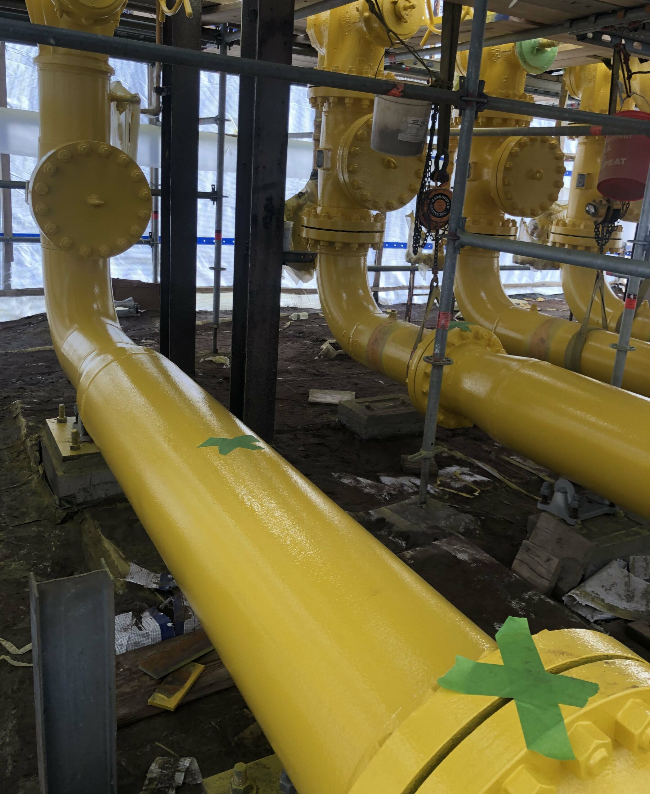 Yellow pipeline with green taped criss corss pattern
